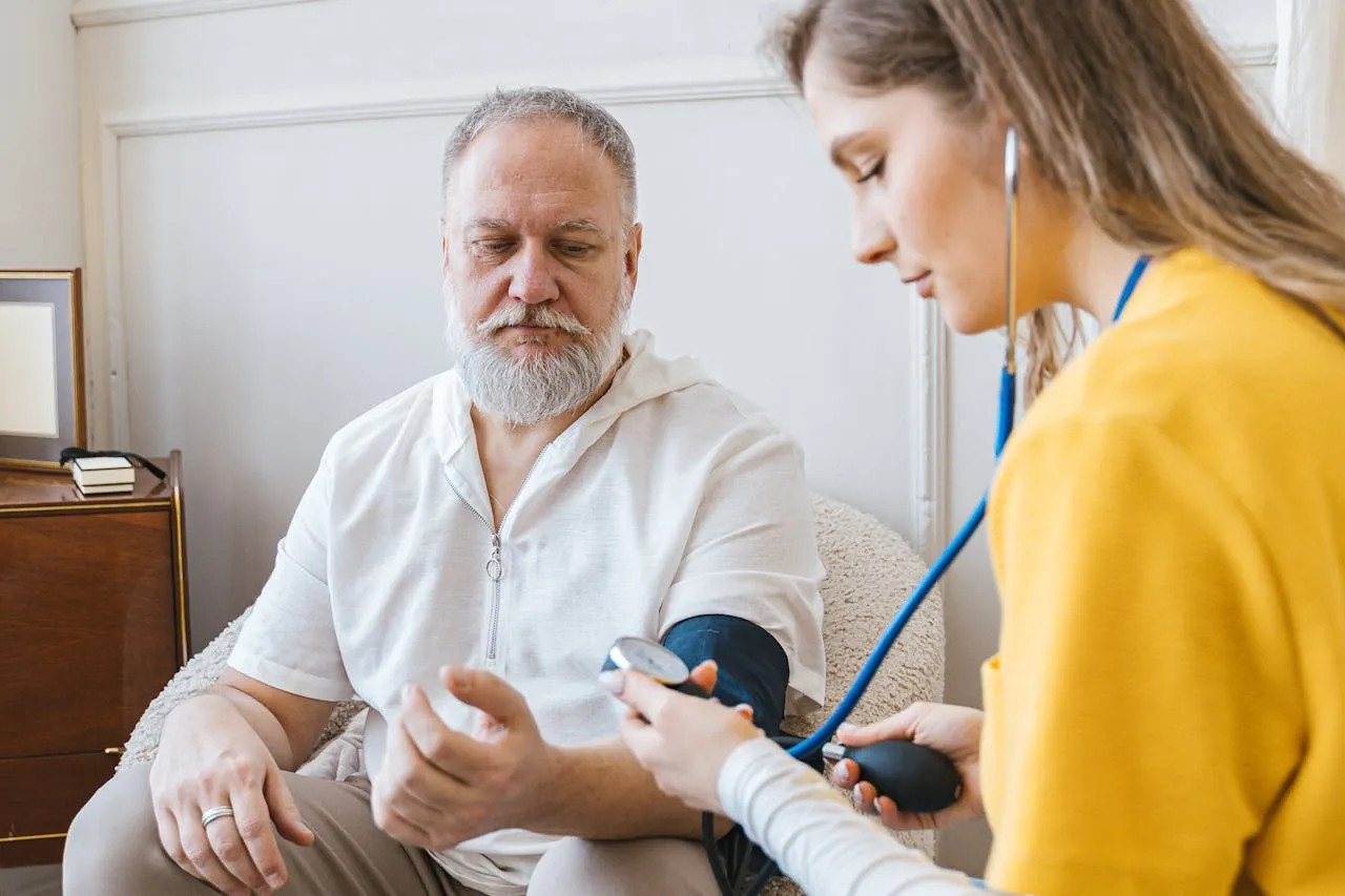 Die Schmeterlingspflege - Ambulanter Pflegedienst - Krankenschwester überprüft den Blutdruck eines alten Mannes